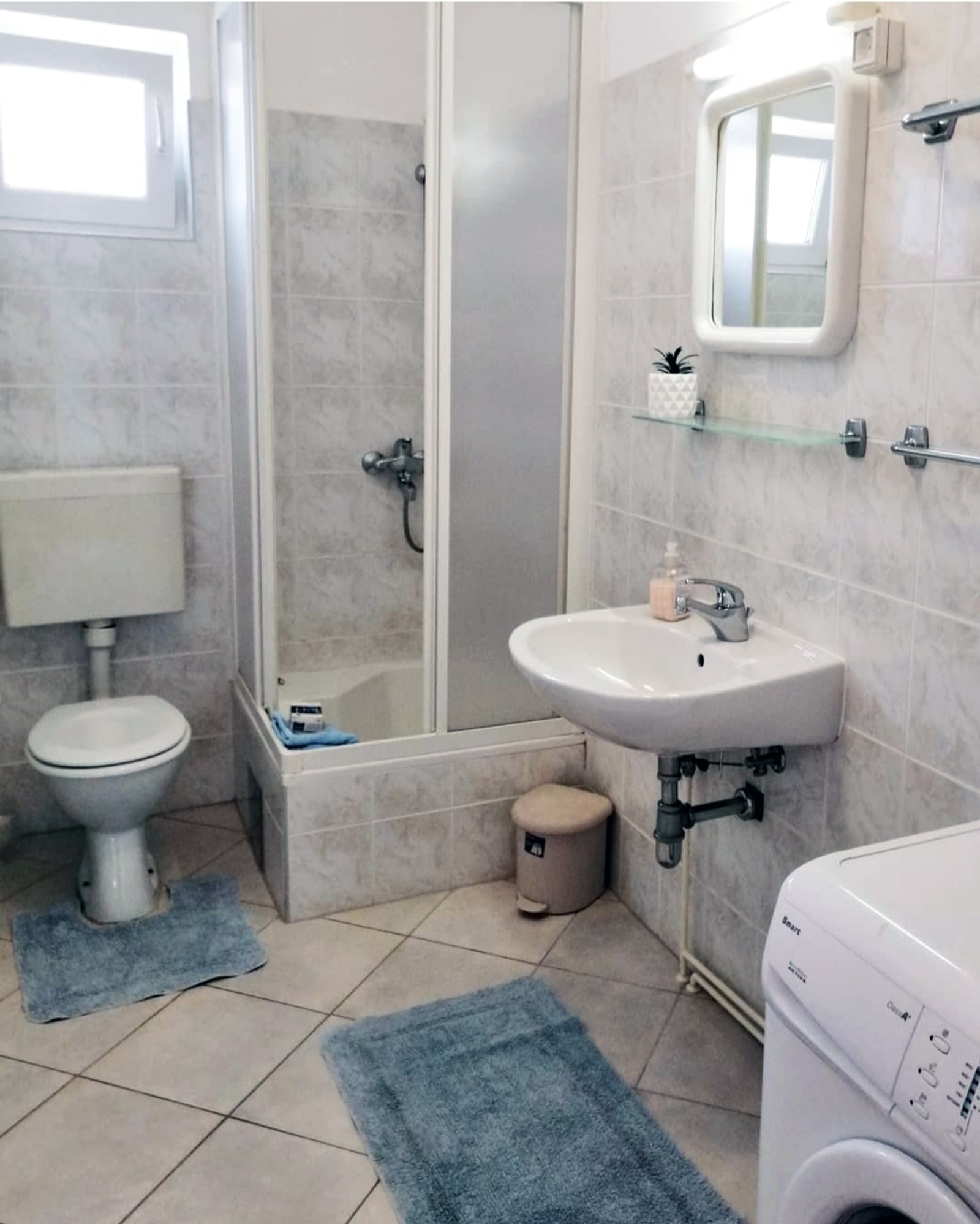 Apartment 3 bathroom sink and tiled shower area